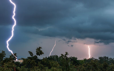 three bolts of lightning over the trees
